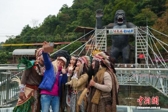 游客与古龙峡景区的“部落野人”合影。柳青 摄 游客与古龙峡景区的“部落野人”合影。柳青 摄