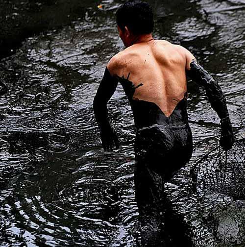 组图:市民跳进池塘抓鱼 不介意水质已受污染(2